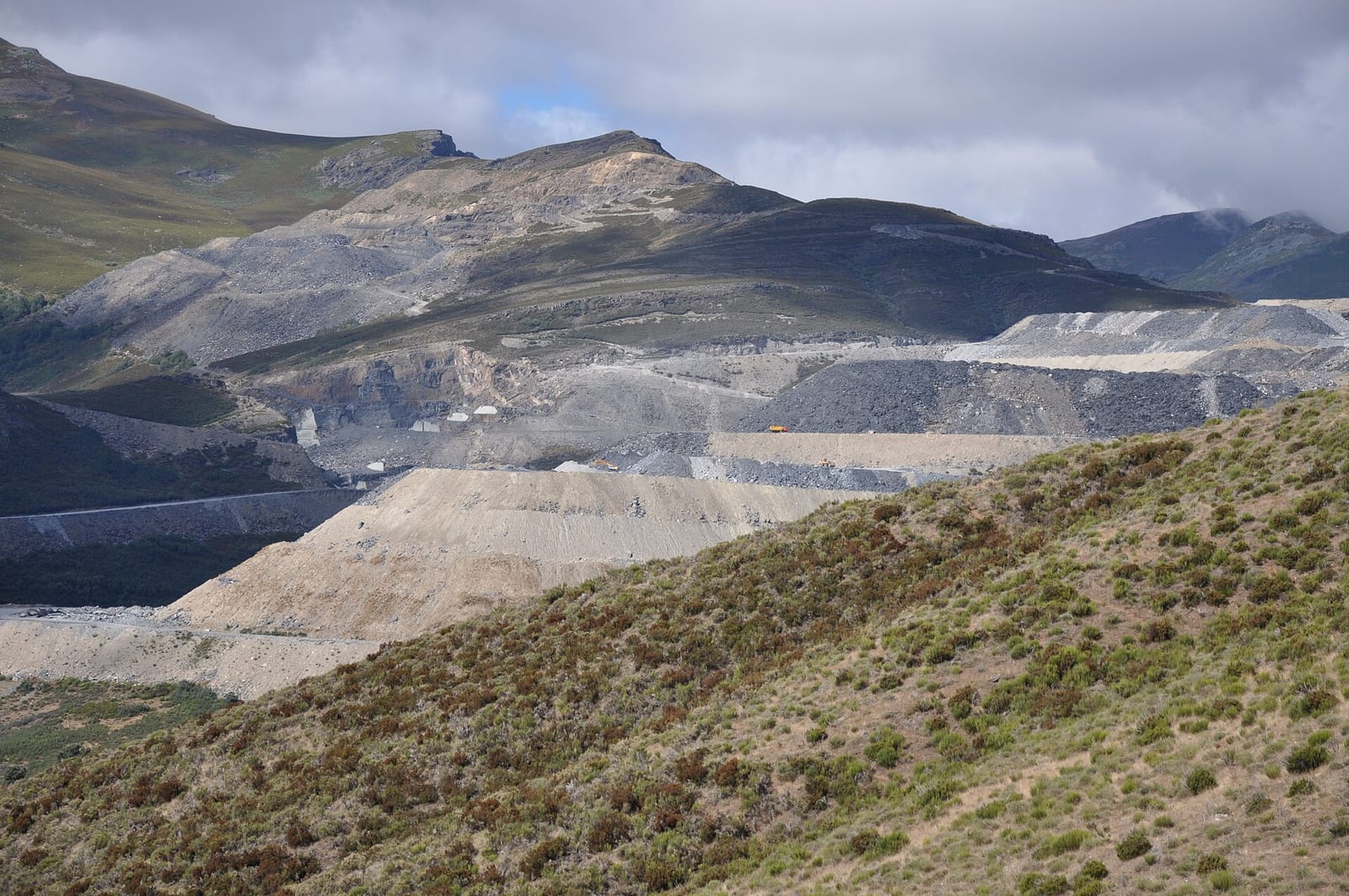 Vista panorámica de una cantera de pizarra a cielo abierto en La Baña, comarca de La Cabrera (León), con bancales excavados y acopios de material